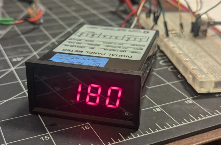 A black box with a 3 digit LED display displaying 180A, connected to circuitry in the background.